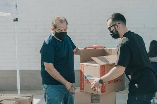 2 men volunteering to move boxes 